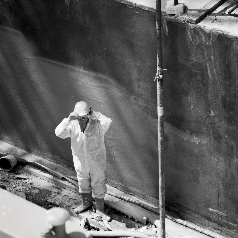 Black and white photo of a person in protective gear on a work site.
